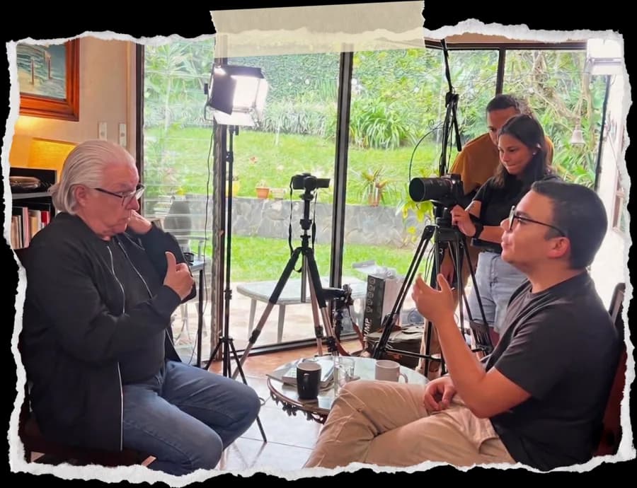 Entrevista grabada en locación, con equipo de cámara y luces de estudio de fondo.